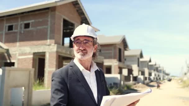 Senior Männliche Architekt Hält Wohnprojekt Blaupause Auf Der Baustelle Vor — Stockvideo