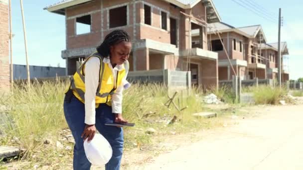 Афроамериканская Работница Осматривает Строительную Площадку Работающую Открытом Воздухе Условиях Чрезмерной — стоковое видео