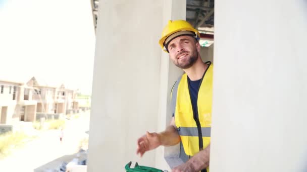 Male Worker Greets Coworkers Construction Site While Working Second Floor — Stock Video