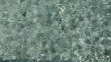Üst görünüm soyut mavi su dalgaları yüzme havuzunda parıldayan yüzey güneş ışığını yansıtır.