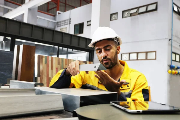 Male technician engineer inspects C-shape steel in metal sheet factory office roof ceiling and wall structure work metal sheets are available in many sizes and thicknesses suitable for the job.