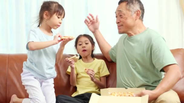 自宅でピザパーティー 彼の2人の孫娘を愛する親切な心のこもった祖父は 喜んで食べる少女のためのランチやスナックのために自宅のファーストフードに配信されたシーフード風味のピザを注文します — ストック動画