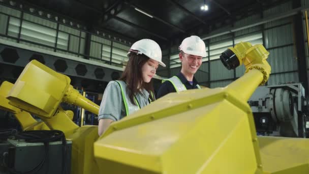 男女电工一边走路一边检查新的大型黄色机器人的维修情况 一边评论现代化的电子自动化装置 — 图库视频影像