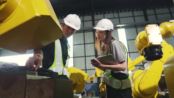 新型大型黄色机器人配备笔记本电脑 现代电子自动化装置 由男女技师组成的工程机械电工负责维修维修工作 — 图库视频影像