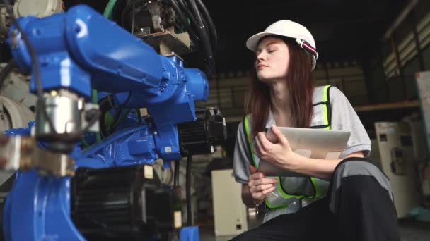 拿着笔记本电脑的白人女电子工程师在仓库里检查一个用现代技术工作的工业机器人的人工智能自动化电力电缆和电路连接 — 图库视频影像