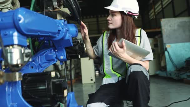 拿着笔记本电脑的白人女电子工程师在仓库里检查一个用现代技术工作的工业机器人的人工智能自动化电力电缆和电路连接 — 图库视频影像