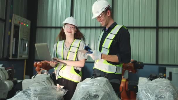 男性と女性のロボット工学エンジニアは 明確な防塵プラスチックで覆われた新しいロボットゾーンロボット倉庫を検査し ラップトップロボットが電気テストを待っています — ストック動画