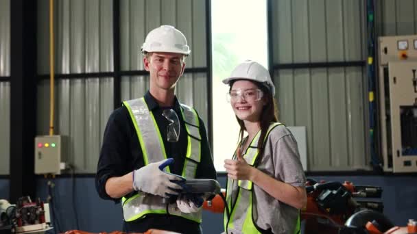 电子自动化电气安装过程中对焊接机器人进行模拟控制检测的男女电工工作坊微笑着竖起大拇指 — 图库视频影像