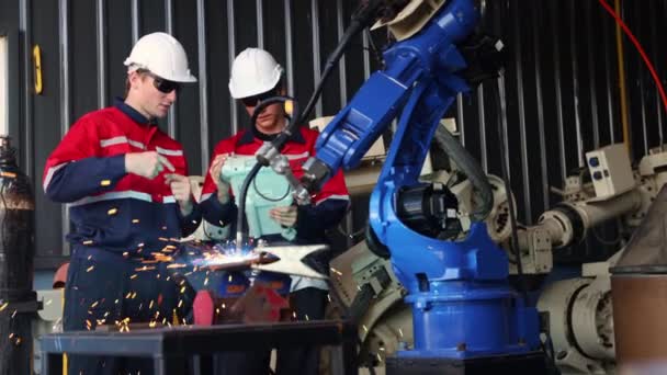 Μηχανικοί Της Ομάδας Φορώντας Προστατευτικά Γυαλιά Λειτουργεί Συγκόλλησης Βραχίονα Ρομπότ — Αρχείο Βίντεο