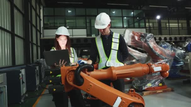 库房现代商业4 0男女电工机器人工程师用手提电脑电子自动化系统检测新型焊接机器人的电气安装过程 — 图库视频影像