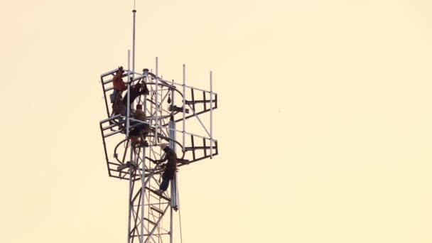 Sylwetka Praca Zespołowa Męskich Robotników Budujących Słup Telekomunikacyjny Wysoka Wieża — Wideo stockowe
