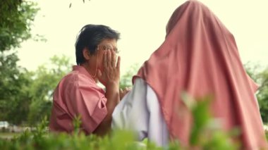 Arkaya bakan Müslüman kadın doktor hastane bahçesindeki yaşlı bir hastayı muayene ediyor. Onu kucaklıyor ve hastaya sağlık ve acil şifalar diliyor..