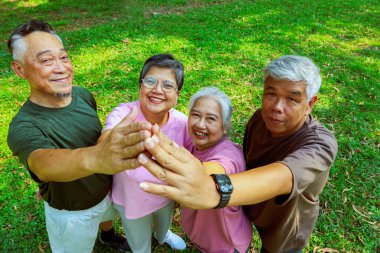 Üst düzey Asyalı emekliler, sağlıklı olanlar el ele tutuşsun. Güçlerini birleştirip spor aktivitelerine katılın. Sabah sporun tadını çıkarın..