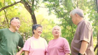 Neşeli Asyalı emekliler, sağlıklı olanlar el ele tutuşsun. Güçlerini birleştirip spor aktivitelerine katılın. Sabah sporun tadını çıkarın..