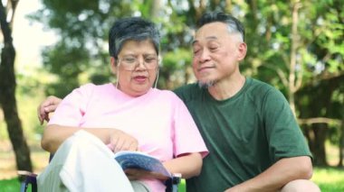 Yaşam tarzı, üst düzey Asyalı çift birlikte kitap okuyarak sağlık hizmetleri ve emeklilikten sonra birbirleriyle ilgilenen gölgeli bir bahçede mutlu bir yaşam sürme hakkında kitap okuyorlar..