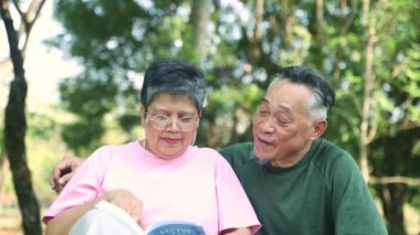 Yaşam tarzı, üst düzey Asyalı çift birlikte kitap okuyarak sağlık hizmetleri ve emeklilikten sonra birbirleriyle ilgilenen gölgeli bir bahçede mutlu bir yaşam sürme hakkında kitap okuyorlar..