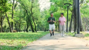 Asyalı yaşlı çift sağlıklı vücut iyi akıl sağlığı yavaş koşu bahçede birlikte sabah egzersizi sağlık hizmetleri emekliliği ve yaşlanma: Karı koca yaşlılar yolda koşuyor.