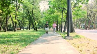 Asyalı yaşlı çift sağlıklı vücut iyi akıl sağlığı yavaş koşu bahçede birlikte sabah egzersizi sağlık hizmetleri emekliliği ve yaşlanma: Karı koca yaşlılar yolda koşuyor.