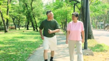Asyalı yaşlı çift sağlıklı vücut iyi akıl sağlığı yavaş koşu bahçede birlikte sabah egzersizi sağlık hizmetleri emekliliği ve yaşlanma: Karı koca yaşlılar yolda koşuyor.