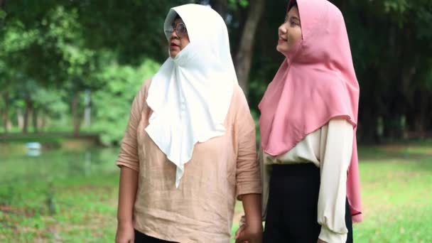 Мусульманская Мать Дочь Ходить Рука Руку Приятном Тенистом Саду Расслабиться — стоковое видео