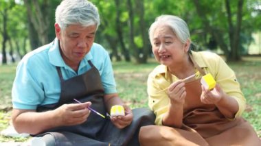 Asyalı yaşlıları bir araya toplayarak etkinliklere katılıyor ve parktaki yeteneklerini gösteriyorlar yaratıcı fikirler rengarenk sıvalar tasarlıyorlar rahatlayın kendinizi iyi ve sağlıklı hissediyorsunuz..