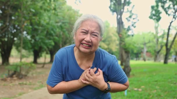 突然の心臓発作を起こした高齢女性の拷問された顔は 庭で運動した後 心筋の漏れの疲労と息切れの痛みを示しています 重度の症状は助けを求める — ストック動画