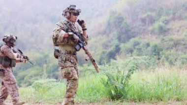 Grup askerleri savaş görevi için toplanıyor, silahlı askerler tehlikeli bir keşif görevinde keşif görevleri için kamufle oluyorlar..