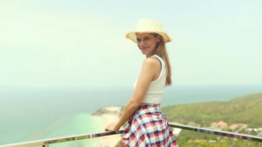 Ada gezisine giden kadın turist kuş bakışı beyaz kumlu sahile hayran kalmış yüksek dağlara bakıyor ve adanın ikinci güzel manzarasına zevkle bakıyor..