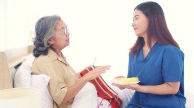 Genç doktorlar ve hemşireler tedavi gören yaşlı kadın hastalarla ilgileniyorlar. Dikiş atarken birbirlerine bakıyorlar ve taze elma yiyorlar. Vücuduna vitamin veriyorlar..