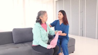 Kadın fizyoterapist hemşire, direnç bantlarının kullanımını öğretir ve denetler. Kasları gerer ve kemik iltihabı olan yaşlı kadınların eklemlerini çeker. Sağlık için kol kaslarını tedavi eder ve geliştirir..