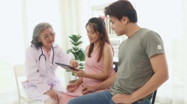 Kıdemli jinekolog hamile kadınlar ve kocalarıyla doğum öncesi kontroller için hastanede tanılar ve doğum öncesi sağlık ve hazırlıklar hakkında tavsiyelerde bulunur..