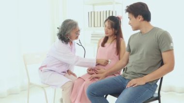 Kıdemli jinekolog hamile kadınlar ve kocalarıyla doğum öncesi kontroller için hastanede tanılar ve doğum öncesi sağlık ve hazırlıklar hakkında tavsiyelerde bulunur..