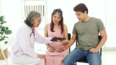 Kıdemli jinekolog hamile kadınlar ve kocalarıyla doğum öncesi kontroller için hastanede tanılar ve doğum öncesi sağlık ve hazırlıklar hakkında tavsiyelerde bulunur..