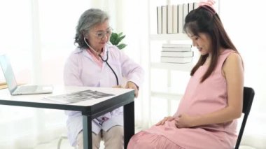 Kıdemli jinekolog, hamile kadınlarla hastanede buluşur, sağlık hizmetleri ile görüşür, doğum öncesi hazırlıkları tartışır, çocuk gelişimini röntgen filmleriyle analiz eder ve sadece iyi şeyler tavsiye eder..