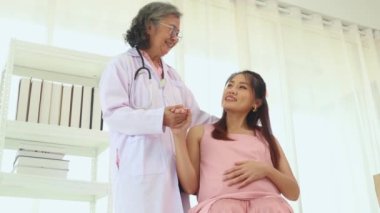 Kıdemli kadın doğum uzmanı hamile bir kadınla sağlık ve doğum öncesi hazırlıkları tartışıyor ve tavsiyelerde bulunuyor. Doktor merhamet gösterecektir ve hastaya en iyi şekilde bakacaktır..