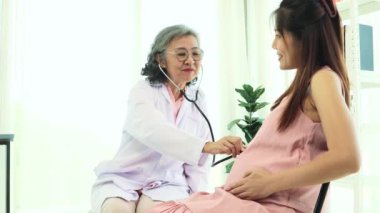 Kıdemli kadın doğum uzmanı hamile bir kadınla sağlık ve doğum öncesi hazırlıkları tartışıyor ve tavsiyelerde bulunuyor. Doktor merhamet gösterecektir ve hastaya en iyi şekilde bakacaktır..