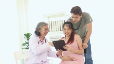 Kıdemli jinekolog hamile kadınlar ve kocalarıyla doğum öncesi kontroller için hastanede tanılar ve doğum öncesi sağlık ve hazırlıklar hakkında tavsiyelerde bulunur..