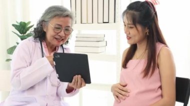 Doğum uzmanı hamile kadın ve kocasını doğum öncesi kontrolleri için hastanede ziyaret ediyor. Fetüsün kalp atış hızını ölçmek için steteskop kullanıyor ve sağlıklı beslenme ve doğum öncesi hazırlıklara ilişkin tavsiyelerde bulunuyor..