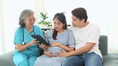 Kıdemli jinekolog hamile kadınlar ve kocalarıyla doğum öncesi kontroller için hastanede tanılar ve doğum öncesi sağlık ve hazırlıklar hakkında tavsiyelerde bulunur..