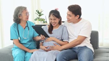 Kıdemli jinekolog hamile kadınlar ve kocalarıyla doğum öncesi kontroller için hastanede tanılar ve doğum öncesi sağlık ve hazırlıklar hakkında tavsiyelerde bulunur..