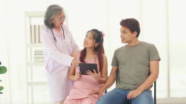 Kıdemli jinekolog hamile kadınlar ve kocalarıyla doğum öncesi kontroller için hastanede tanılar ve doğum öncesi sağlık ve hazırlıklar hakkında tavsiyelerde bulunur..