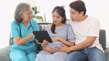 Kıdemli jinekolog hamile kadınlar ve kocalarıyla doğum öncesi kontroller için hastanede tanılar ve doğum öncesi sağlık ve hazırlıklar hakkında tavsiyelerde bulunur..