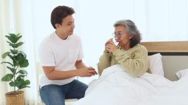 Oğlu, yaşlı annesinin sağlığına, kemiklerini güçlendirmek için kalsiyum, mineral ve besin maddeleri içeren sütü vererek iyi niyetini gösteriyor..