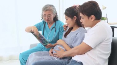 Kıdemli jinekolog hamile kadınlar ve kocalarıyla doğum öncesi kontroller için hastanede tanılar ve doğum öncesi sağlık ve hazırlıklar hakkında tavsiyelerde bulunur..