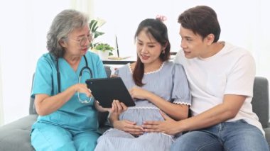 Kıdemli jinekolog hamile kadınlarla ve kocalarıyla doğum öncesi kontroller için hastanede tanılar ve doğum öncesi sağlık ve hazırlıklar hakkında tavsiyelerde bulunur..