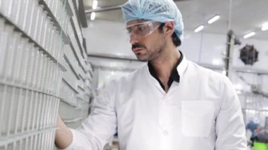 Erkek QC çalışanı, konserve balık konserveleri, kalite ve temizlik için uskumru içeren alüminyum kutuların kalitesini kontrol ediyor..