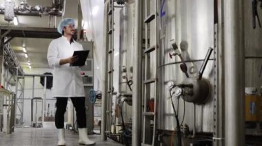 Erkek teknisyen, konserve balıkları üretim hattında sterilize etmek ve anormallikleri araştırmak için alet çantasıyla birlikte teçhizat buhar kazanını inceliyor. Konserve balık fabrikasının bakımını planlıyorlar..