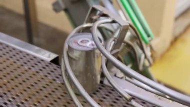 İçinde uskumru dolu alüminyum teneke kutular ve temiz kapaklar modern bir konserve fabrikasının temizliği için sıcak su temizleme noktasına bir taşıyıcı bant ile taşınır..