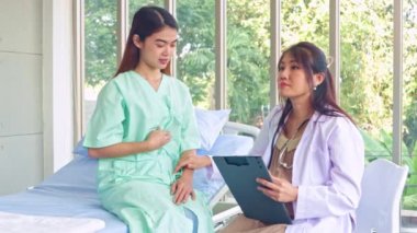 Hasta olan ve hastanede tedavi gören kadın hastaları muayene eden hamile kadın doktor hastanın semptomlarını ilk teşhisi koyuyor..