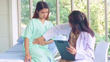 Hasta olan ve hastanede tedavi gören kadın hastaları muayene eden hamile kadın doktor hastanın semptomlarını ilk teşhisi koyuyor..